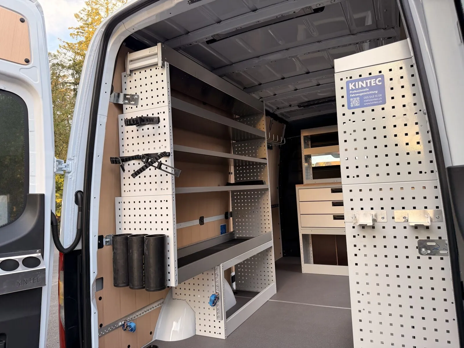 Blick schräg durch die Hecktüren eines Sprinter: links Lochwände mit Haltern und Regale, hinten ein Schubladenblock