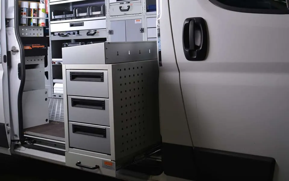 Schubkästen und Koffertablare übereinander an der Seitenwand eines Transporters