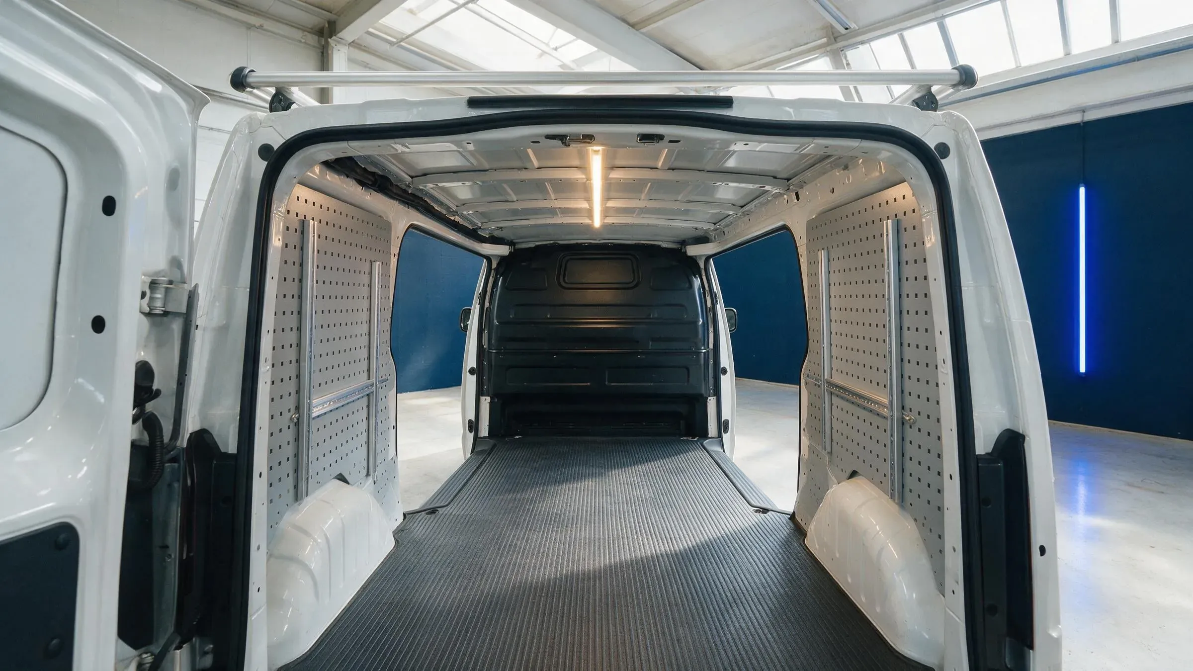 Leerer Laderaum mit blanken Montageschienen, symmetrisch von hinten