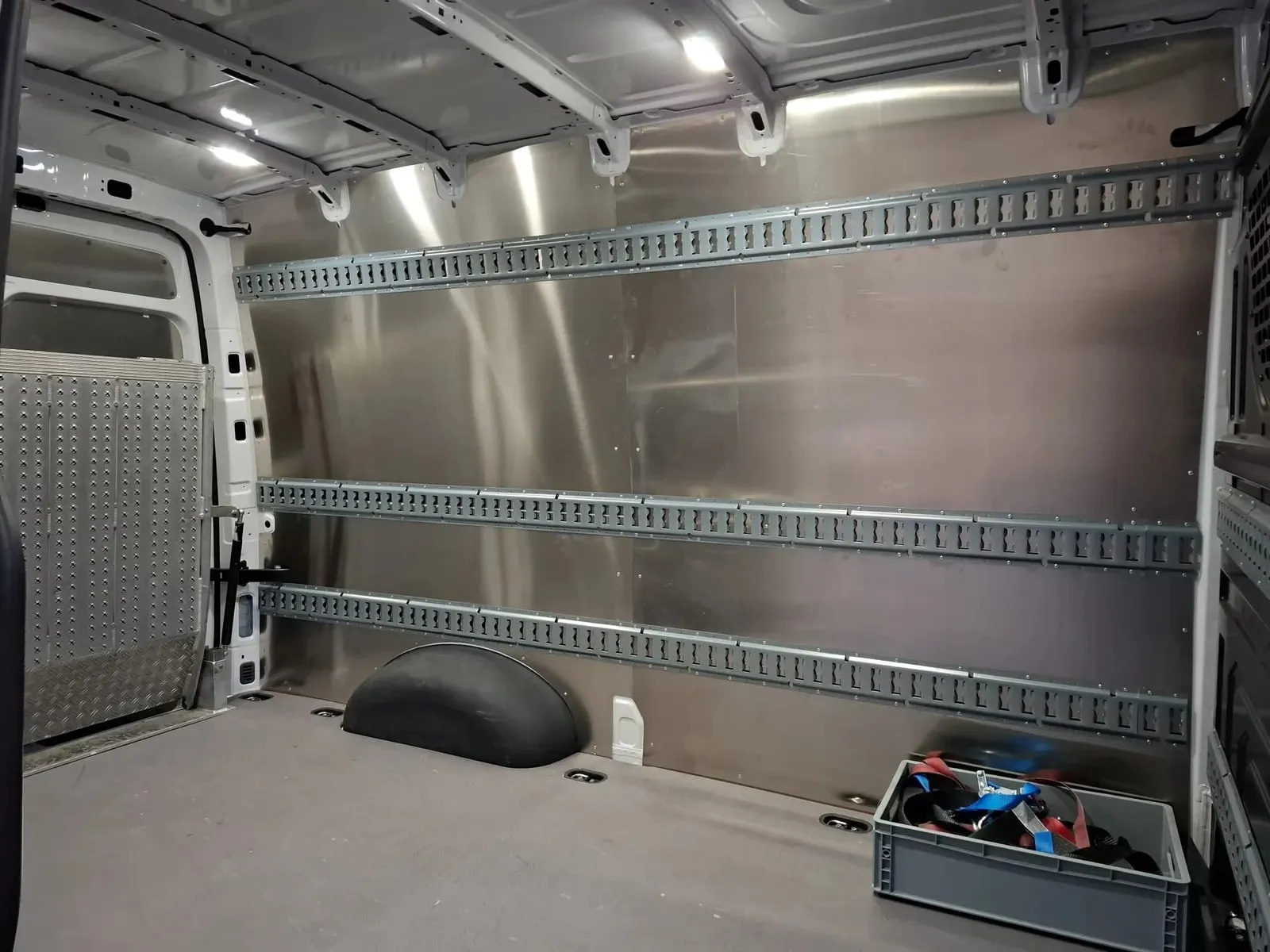 Seitenwand eines Crafter mit Aluminiumverkleidung und drei Zurrschienen übereinander