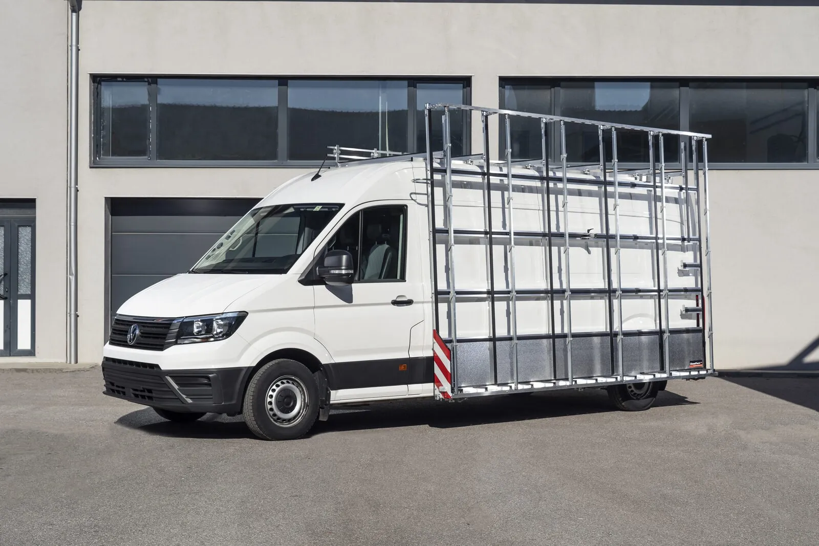 Weisser VW Crafter mit Glasreff an der Seitenwand, vor einer Werkhalle